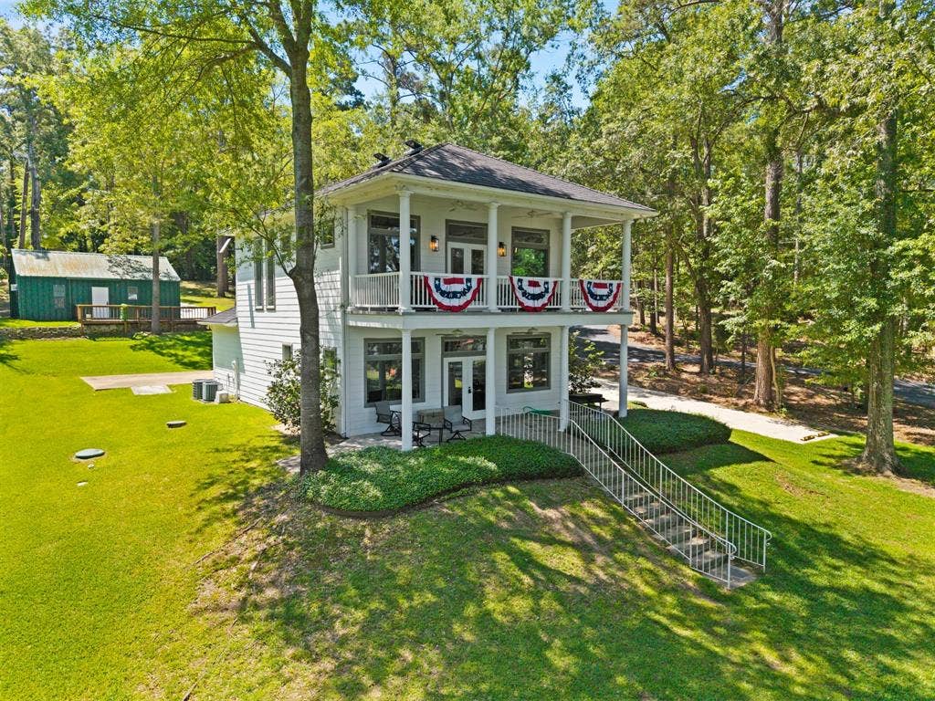 18630 Eastside Road, Troup, TX 75789 Two-story exterior with dual covered balconies, white siding, and a dark shingle roof