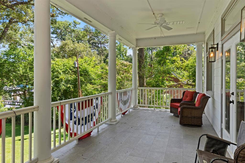 18630 Eastside Road, Troup, TX 75789 Covered porch with tile flooring, white columns, decorative railing, and ceiling fan