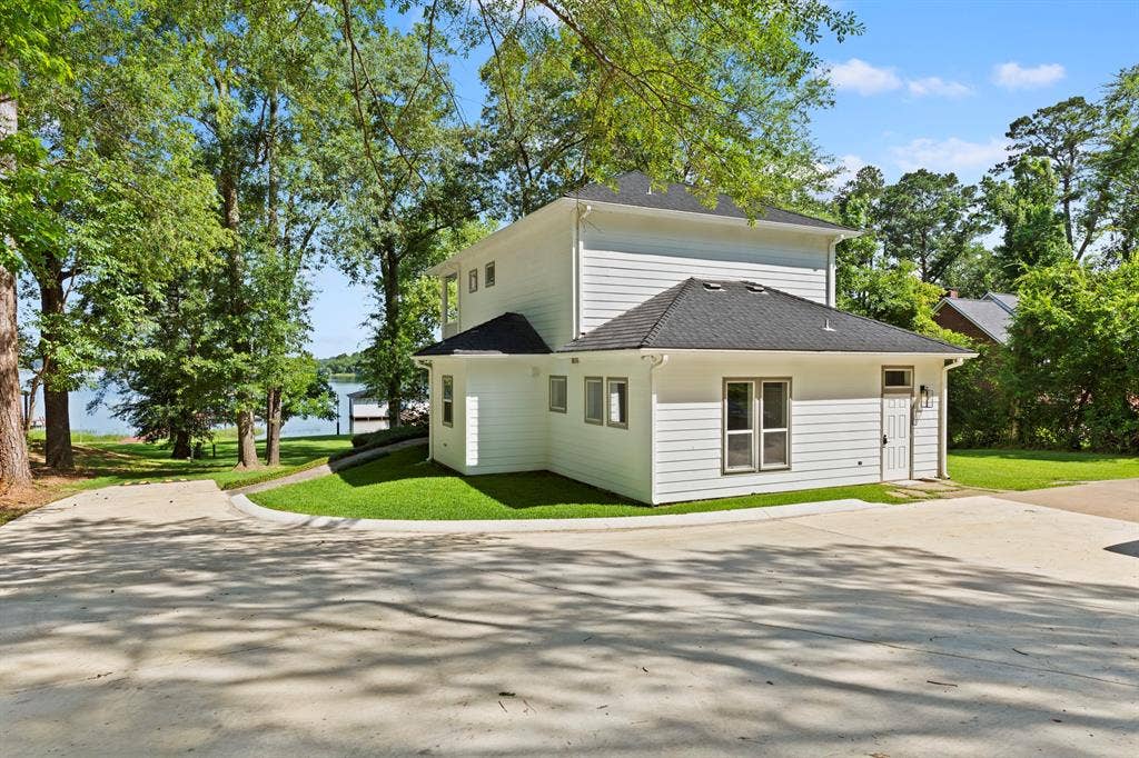 18630 Eastside Road, Troup, TX 75789 Modern farmhouse-style residence featuring clean white exterior siding, a pitched roof with dark shingles, and a wraparound design