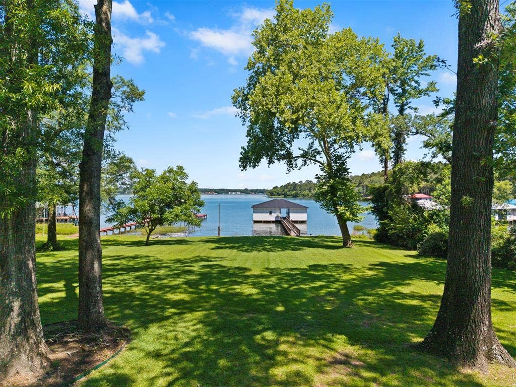 18630 Eastside Road, Troup, TX 75789 Expansive waterfront property featuring a boat house, private dock, and manicured lawn