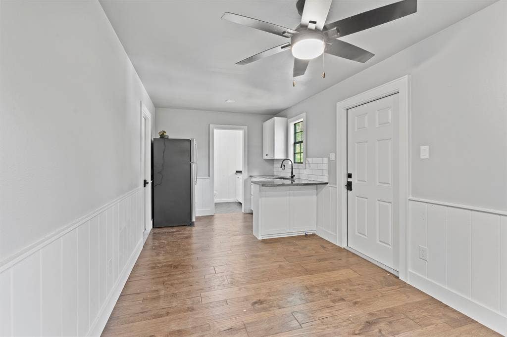 18630 Eastside Road, Troup, TX 75789 Wood-finish flooring throughout, white wainscoting, and a ceiling fan with integrated lighting