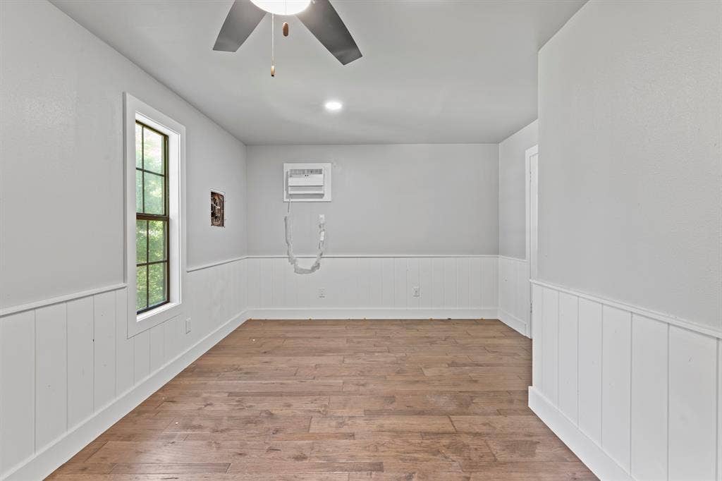18630 Eastside Road, Troup, TX 75789 Wood-finish flooring with white wainscoting and a single window