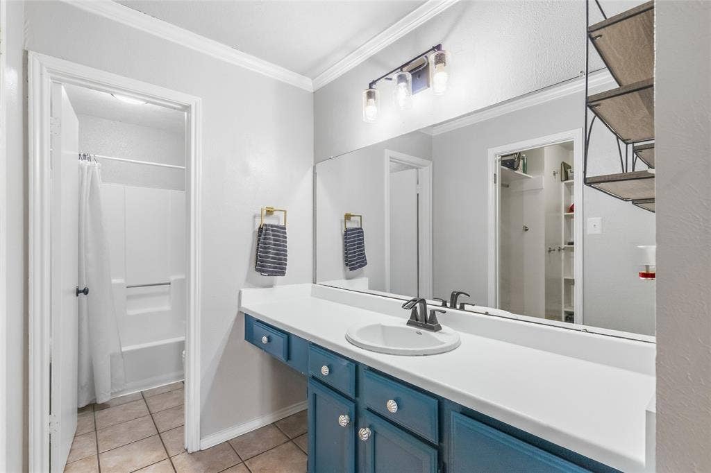 5010 Utah Street, Greenville, TX 75402 Vanity with integrated sink, white countertop, and teal cabinetry