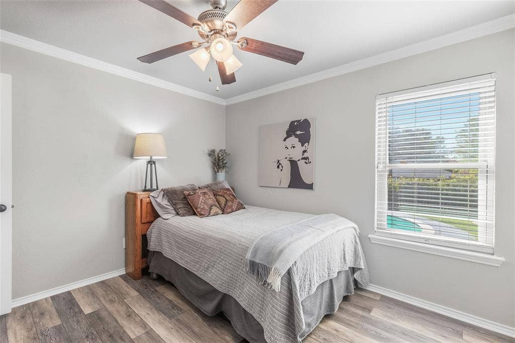 5010 Utah Street, Greenville, TX 75402 Wood-finish flooring, crown molding, and a ceiling fan with integrated lighting