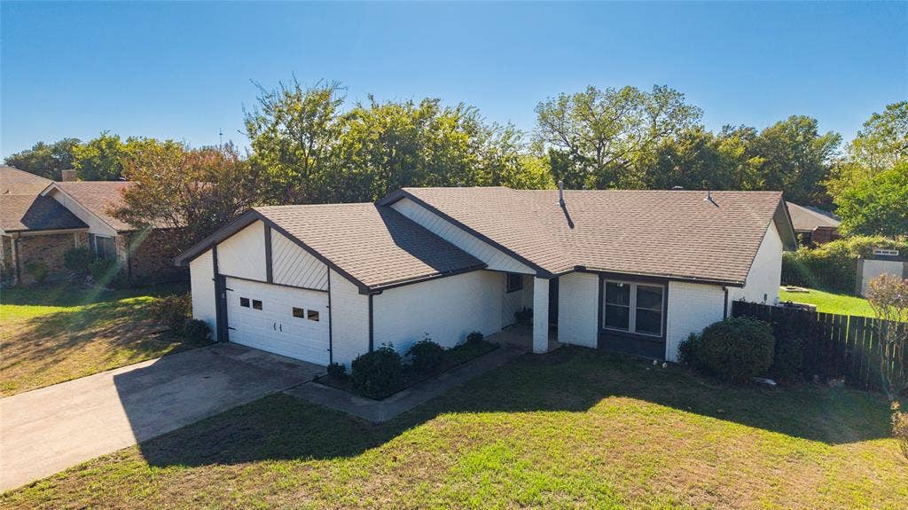 5010 Utah Street, Greenville, TX 75402 Single-story residence featuring a two-car garage, pitched shingle roof, and a privacy fence