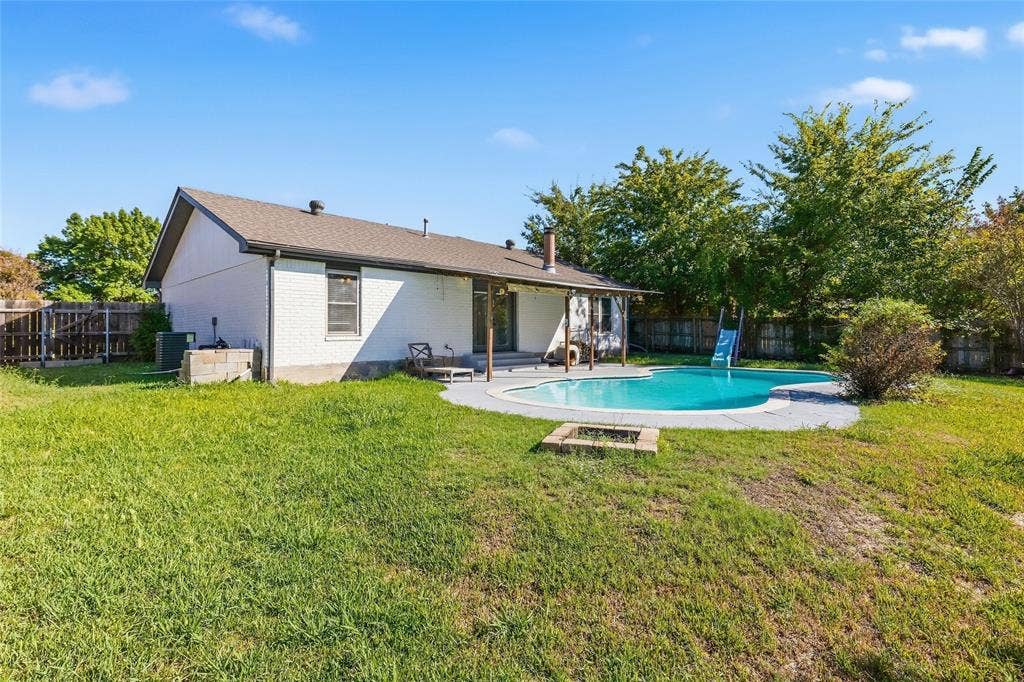 5010 Utah Street, Greenville, TX 75402 Spacious backyard featuring a built-in swimming pool, a covered patio, a fire pit, and a privacy fence