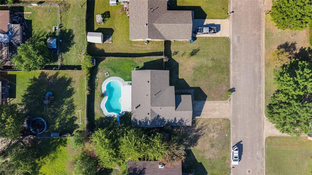 5010 Utah Street, Greenville, TX 75402 Property featuring a private swimming pool, concrete pool decking, and an expansive lawn