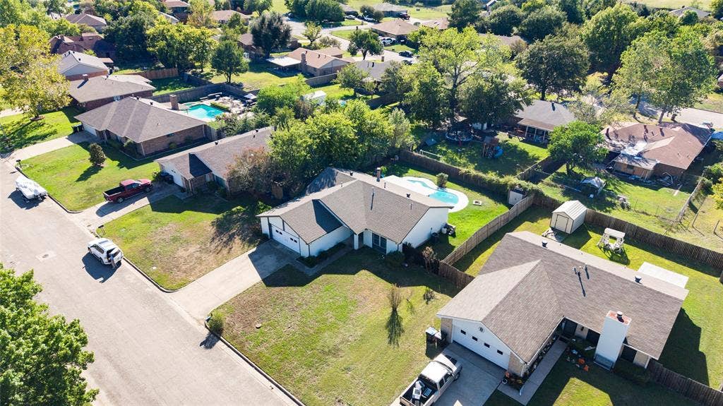 5010 Utah Street, Greenville, TX 75402 Single-story residence with an attached garage, featuring a paved driveway and a fenced backyard with an in-ground pool