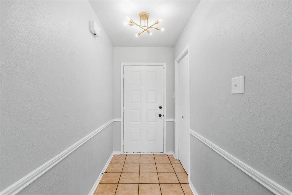5010 Utah Street, Greenville, TX 75402 Entryway featuring tile flooring, wainscoting, and a decorative ceiling light fixture