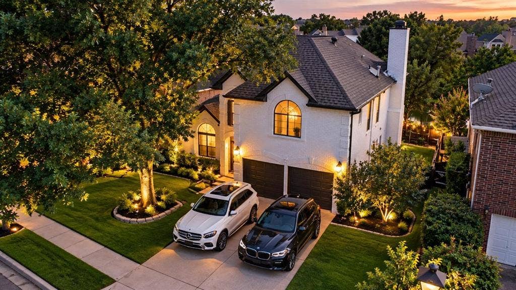 308 Riverwalk Lane, Irving, TX 75063 White exterior residence with a dark shingle roof, arched windows, and a two-car garage