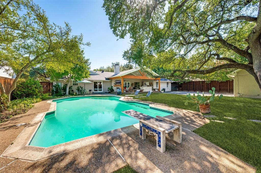 4521 Nashwood Lane, Dallas, TX 75244 Expansive backyard with a large swimming pool, diving board, and concrete decking