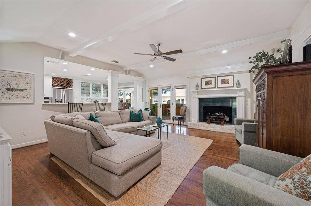 4521 Nashwood Lane, Dallas, TX 75244 Hardwood flooring, vaulted ceiling with exposed beams, built-in fireplace with stone hearth, recessed lighting, and a ceiling fan