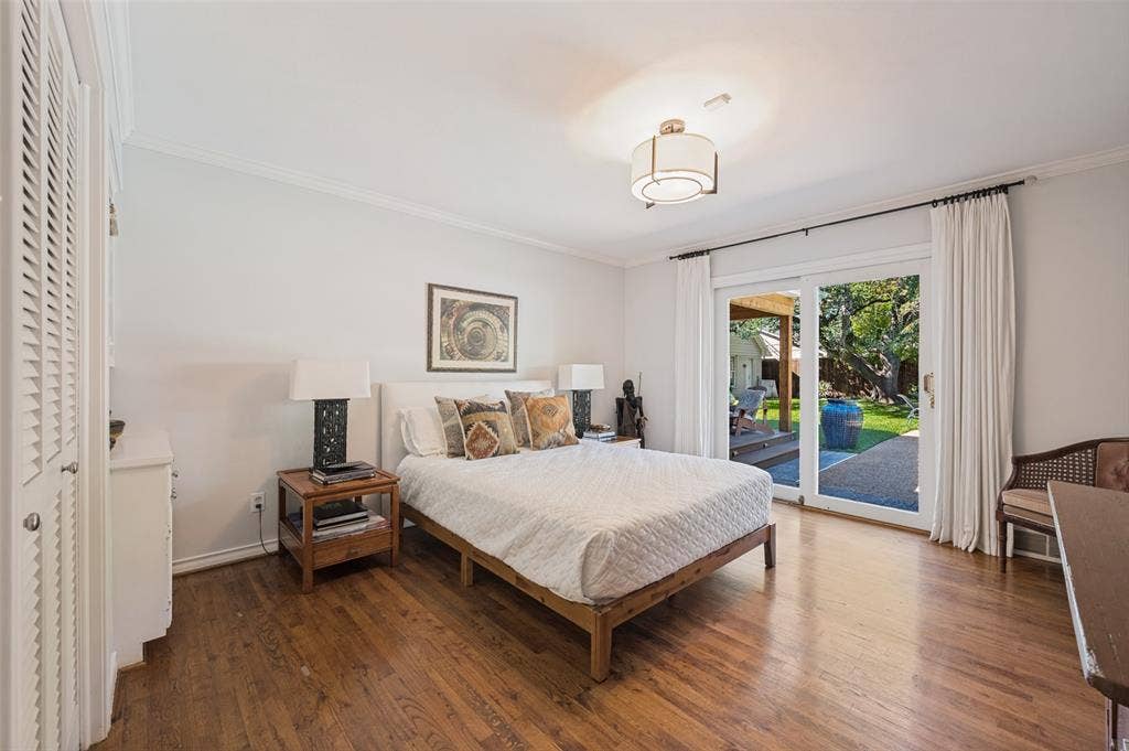 4521 Nashwood Lane, Dallas, TX 75244 Hardwood flooring, crown molding, built-in louvered closet, ceiling-mounted light fixture, and sliding glass door leading to the pool area.