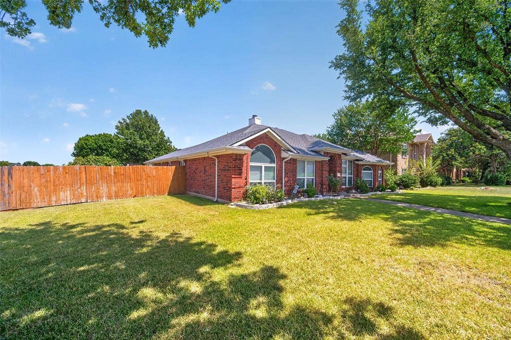 1101 Boyd Drive, Wylie, TX 75098 Red brick exterior with white trim, arched windows, and a dark roof