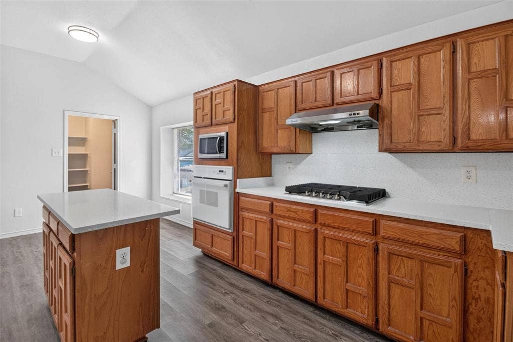 1101 Boyd Drive, Wylie, TX 75098 Wood-finish flooring, vaulted ceiling, and built-in white appliances