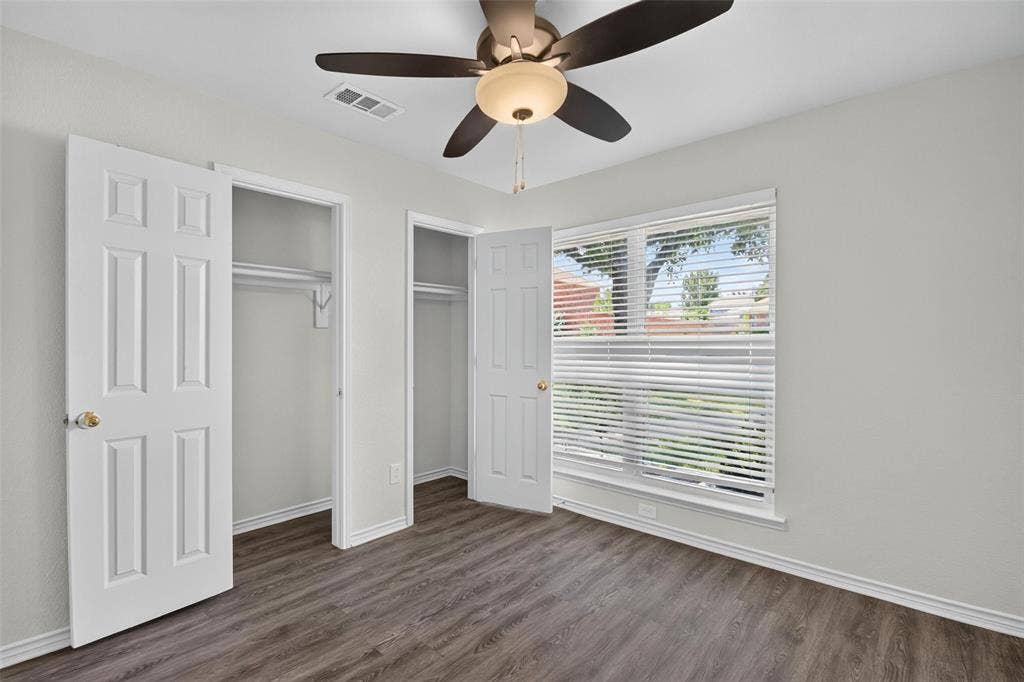 1101 Boyd Drive, Wylie, TX 75098 Wood-finish flooring, ceiling fan with integrated lighting, window with blinds, and dual closets with bi-fold doors