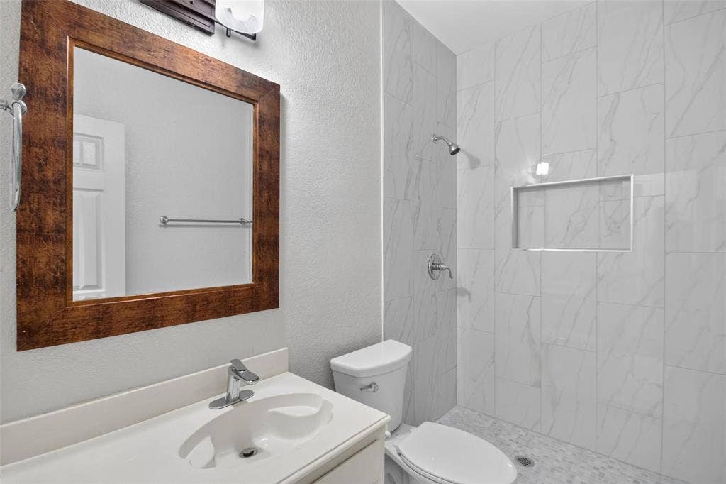 1101 Boyd Drive, Wylie, TX 75098 Vanity with white countertop and integrated sink, chrome faucet, and framed mirror