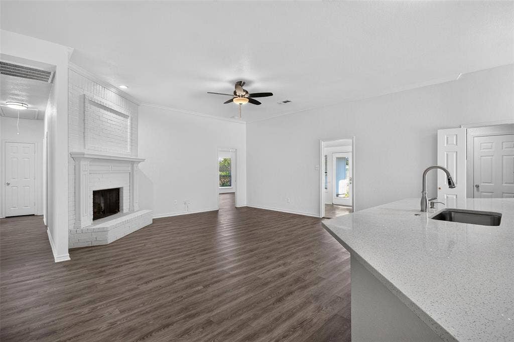 1101 Boyd Drive, Wylie, TX 75098 Spacious living area featuring a white brick fireplace, wood-finish flooring, and a ceiling fan