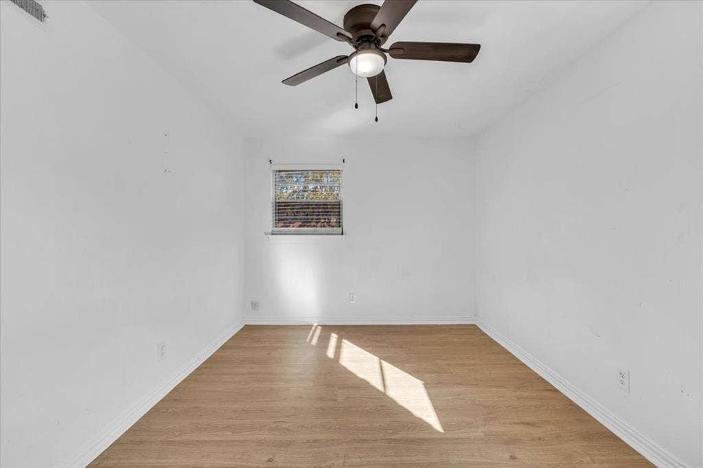 13521 Flagstone Lane, Dallas, TX 75240 Wood-finish flooring, ceiling fan with integrated lighting, and window with blinds