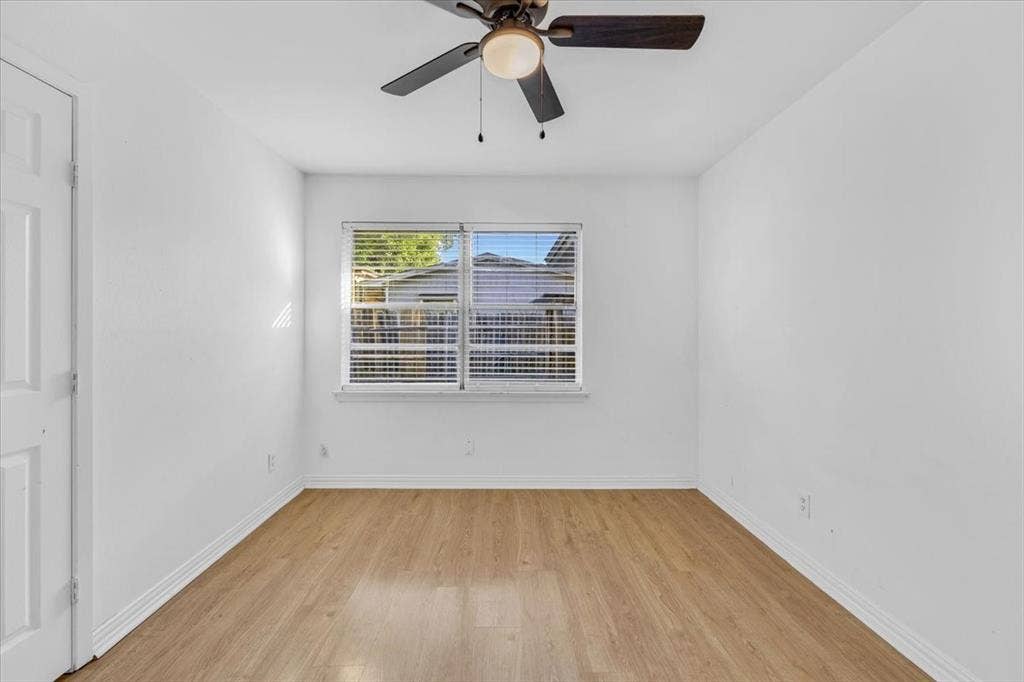 13521 Flagstone Lane, Dallas, TX 75240 Wood-finish flooring, a window with horizontal blinds, and a ceiling fan with integrated lighting