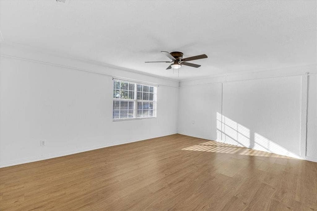 13521 Flagstone Lane, Dallas, TX 75240 Wood-finish flooring, white painted walls, window with blinds, and a ceiling fan with integrated lighting