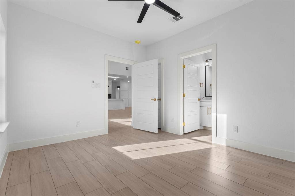 Light wood-finish flooring throughout, white walls, and a contemporary ceiling fan