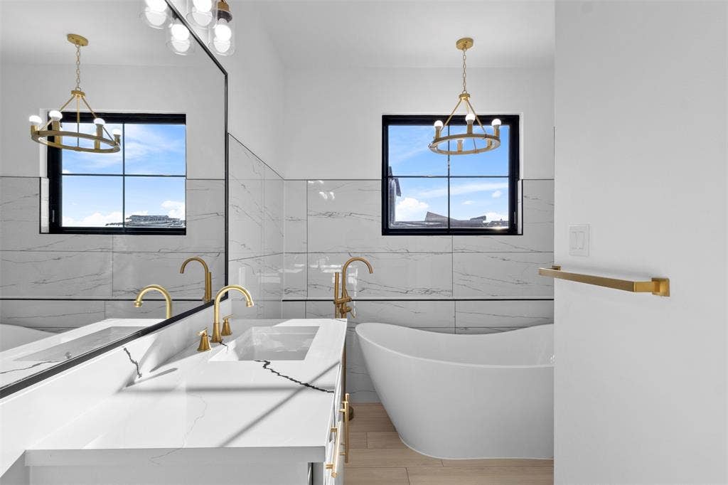 Dual vanity with undermount sinks, gold-finish fixtures, and a white countertop