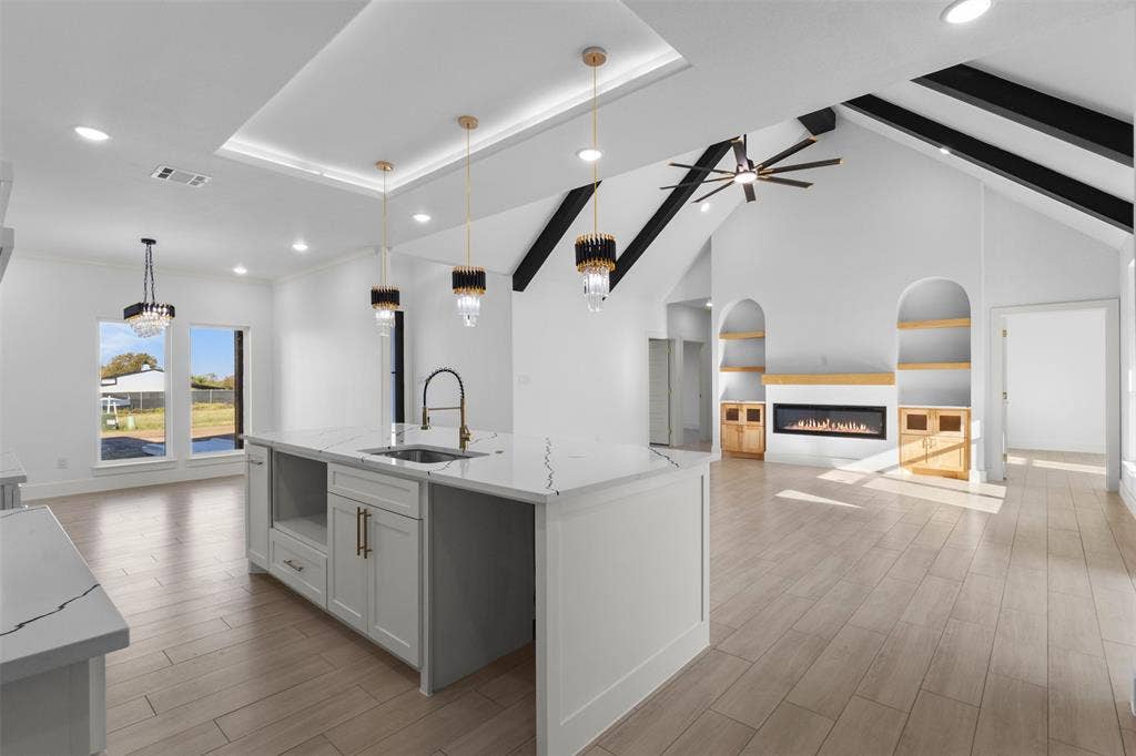 Kitchen island with integrated sink, quartz countertop, and pendant lighting