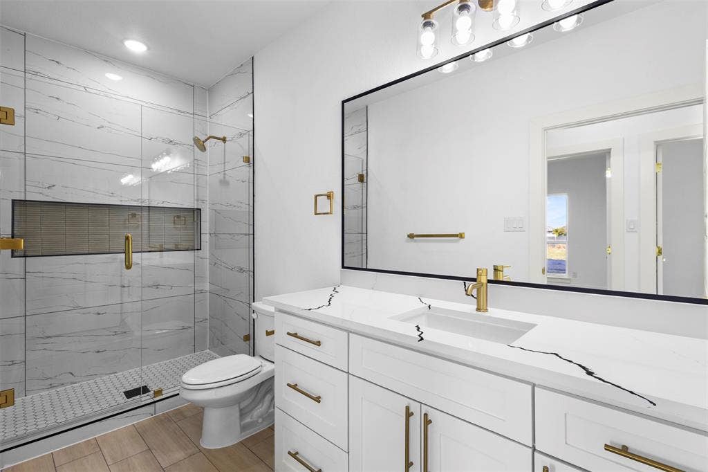 Walk-in shower with clear glass enclosure and tile surround