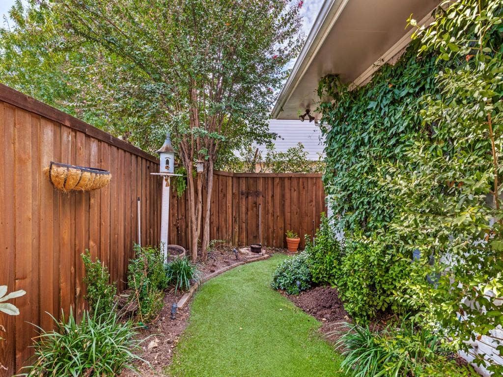 5718 Trail Meadow Drive, Dallas, TX 75230 Landscaped backyard with turf tall wooden privacy fence