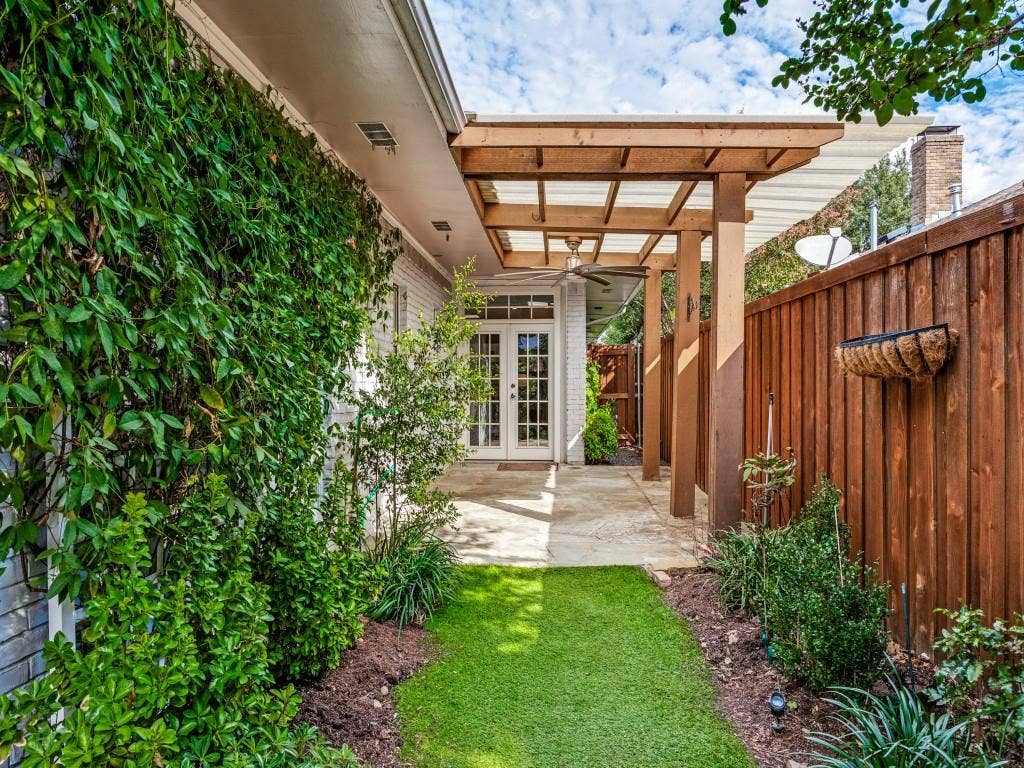 5718 Trail Meadow Drive, Dallas, TX 75230 Landscaped backyard with turf and garden beds