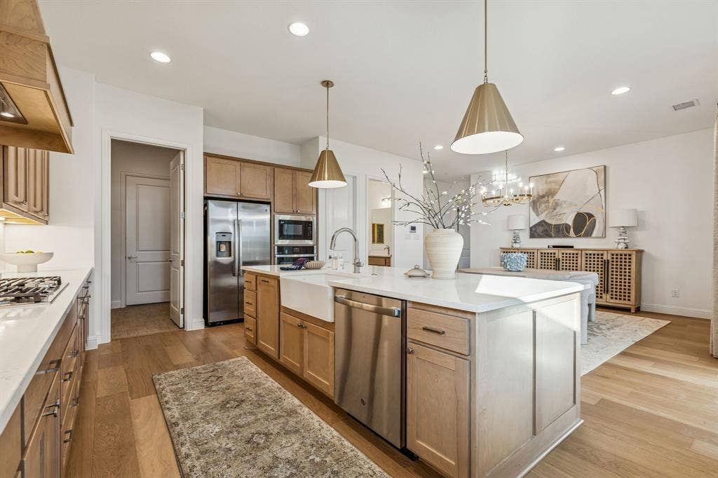 Open-concept kitchen featuring wood-finish flooring, recessed lighting, and a kitchen island with pendant lighting