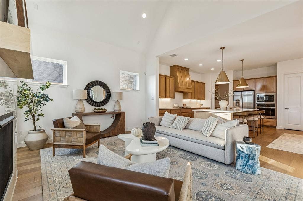 Vaulted ceiling, wood-finish flooring, recessed lighting, kitchen island with seating, pendant lighting