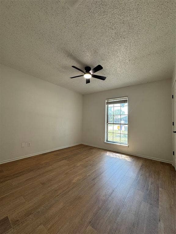 Wood-finish flooring with a satin finish, single window with blinds, and a ceiling fan with integrated lighting