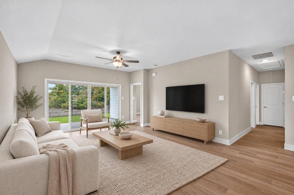 6108 Chickney Drive, Princeton, TX 75071 Neutral-toned interior featuring vaulted ceilings, wood-finish flooring, a ceiling fan with integrated lighting, and a multi-panel sliding glass door