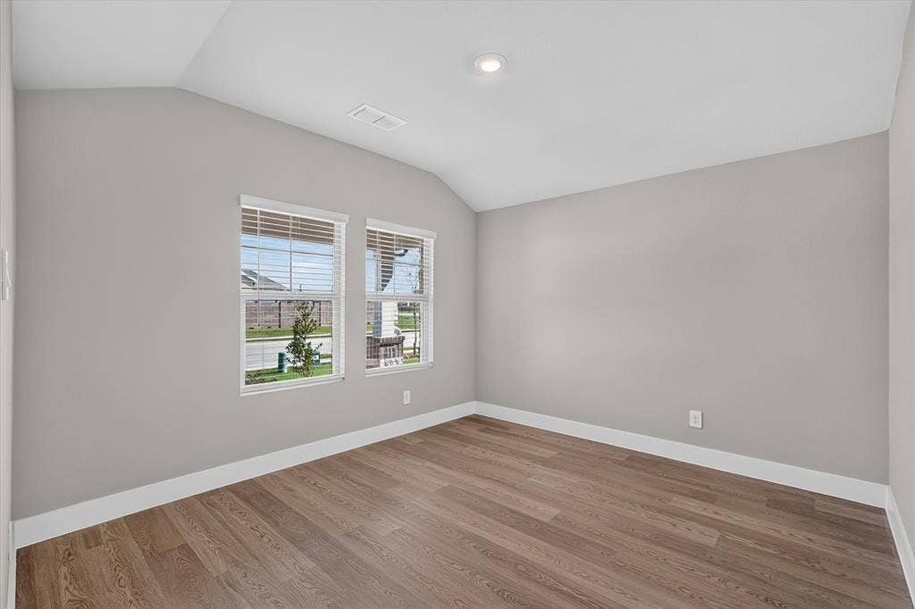 6108 Chickney Drive, Princeton, TX 75071 Interior room featuring vaulted ceilings, wood-finish flooring, and dual windows with integrated blinds