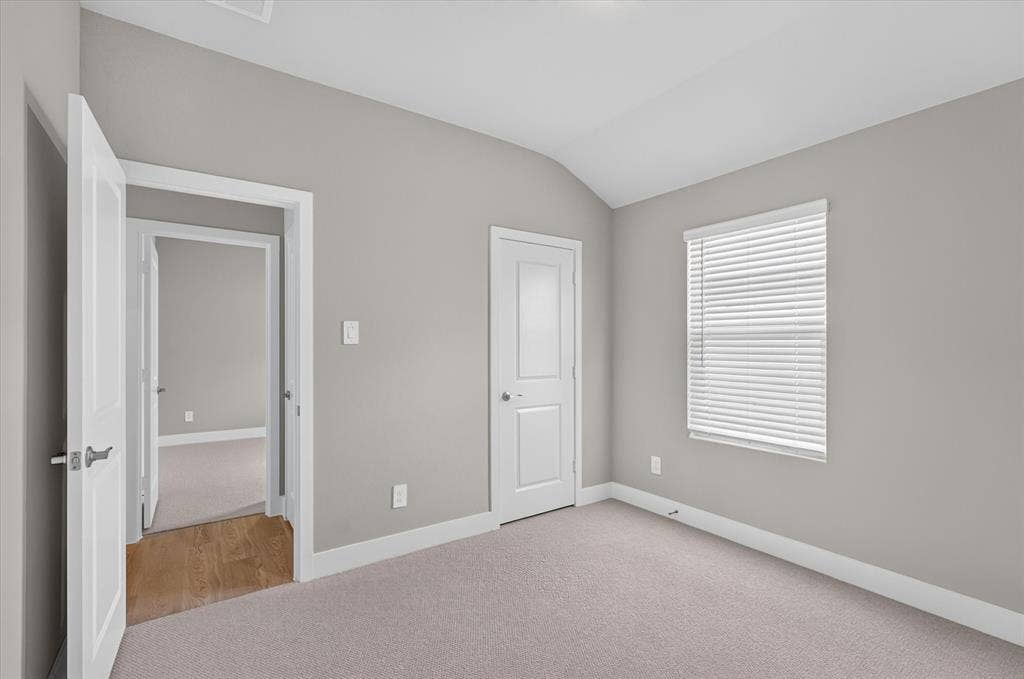 6108 Chickney Drive, Princeton, TX 75071 Neutral-toned room featuring vaulted ceilings, carpeting, interior doors with satin nickel hardware, and a window with horizontal blinds