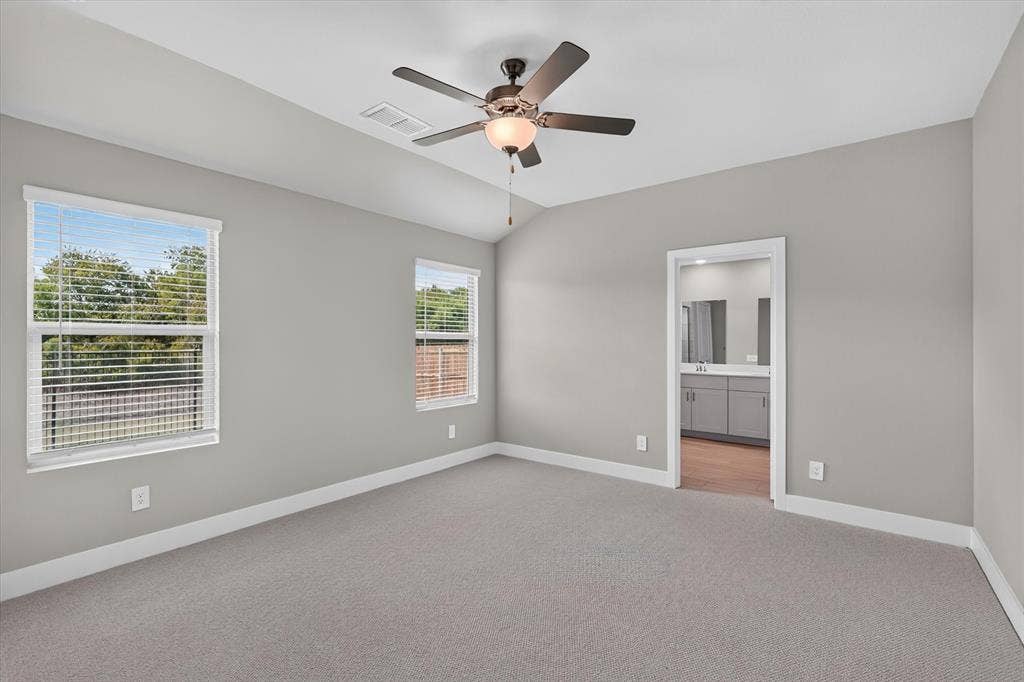 6108 Chickney Drive, Princeton, TX 75071 Room featuring vaulted ceilings, neutral-toned carpeting, two windows, and a central ceiling fan with an integrated light fixture