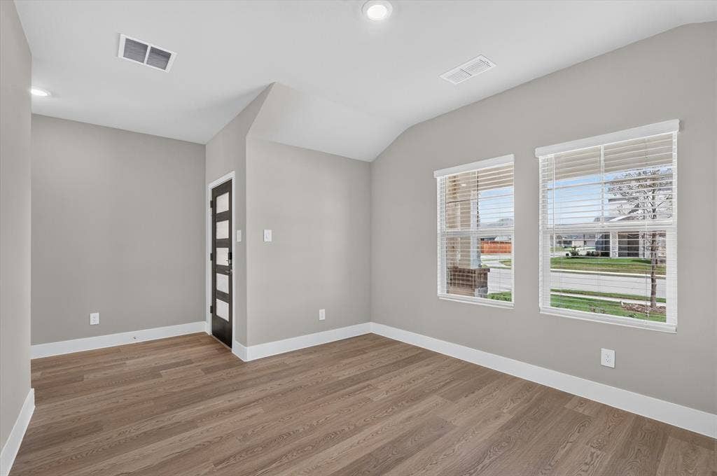 6108 Chickney Drive, Princeton, TX 75071 Neutral wall tones, wood-finish flooring, vaulted ceilings, and a multi-panel exterior door with glass inserts