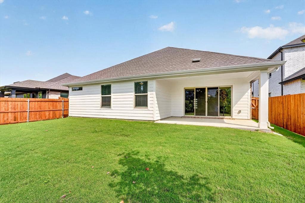 6108 Chickney Drive, Princeton, TX 75071 Rear exterior featuring horizontal lap siding, a covered concrete patio, sliding glass doors, and a wood privacy fence enclosing the backyard