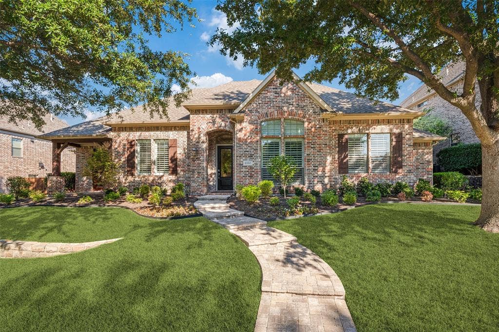 6168 Sweeney Trail, Frisco, TX 75034 Brick exterior with stone accents, a covered entry, and a paver walkway
