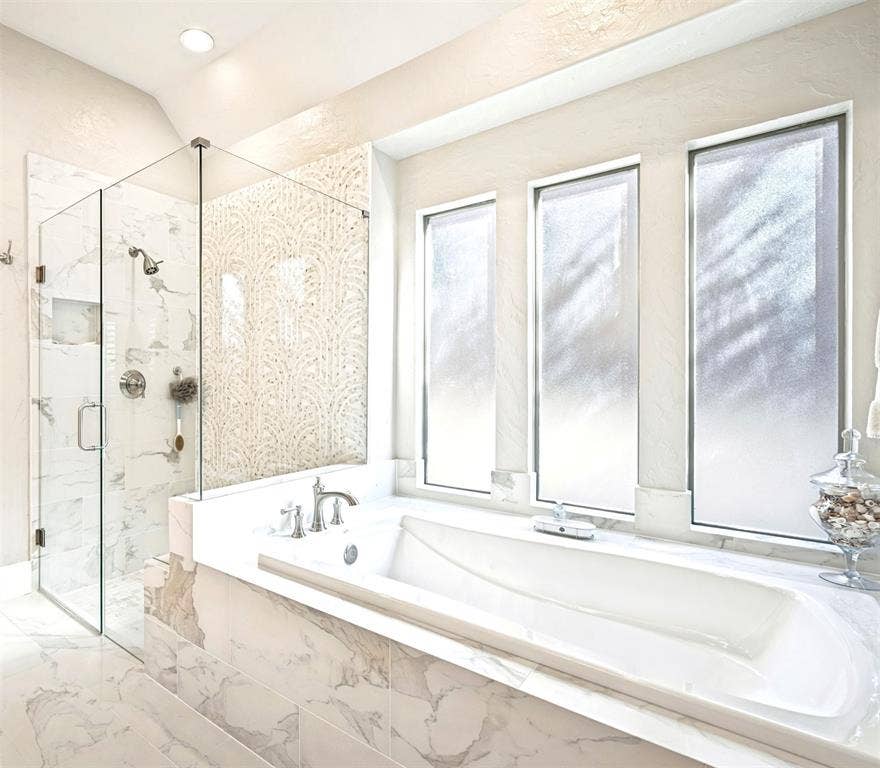 6168 Sweeney Trail, Frisco, TX 75034 Built-in soaking tub, walk-in shower with glass enclosure, marble-style tile surround, decorative accent wall tile, and recessed lighting