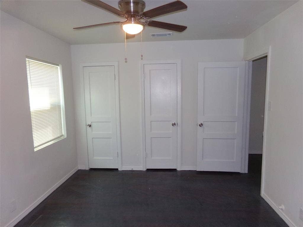 3423 Texas Drive, Dallas, TX 75211 Dark-toned flooring, white walls, and a ceiling fan with light fixture