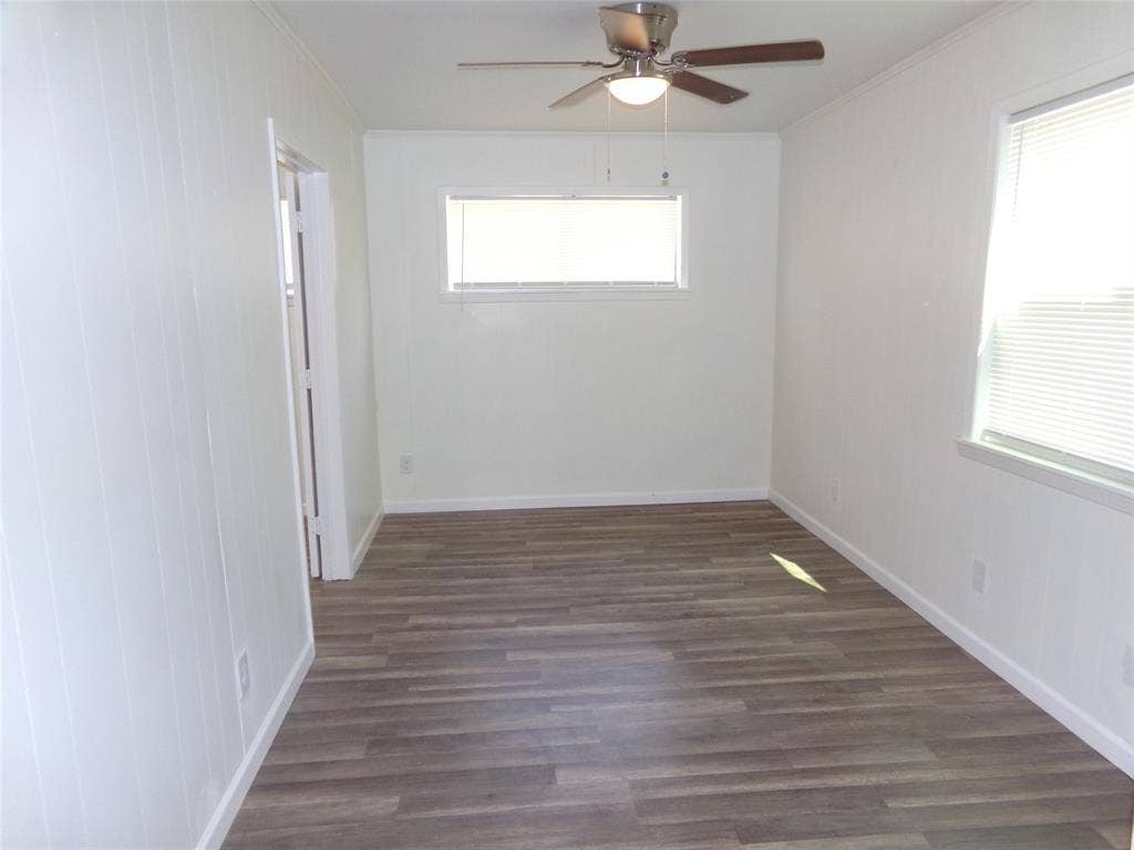 3423 Texas Drive, Dallas, TX 75211 Wood-finish flooring, white paneled wall, dual windows, and ceiling fan with integrated lighting