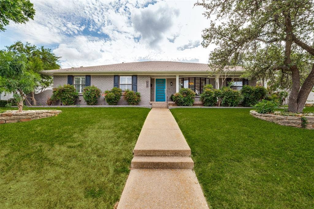 9421 Meadowknoll Drive, Dallas, TX 75243 Grey brick exterior with a vibrant turquoise front door