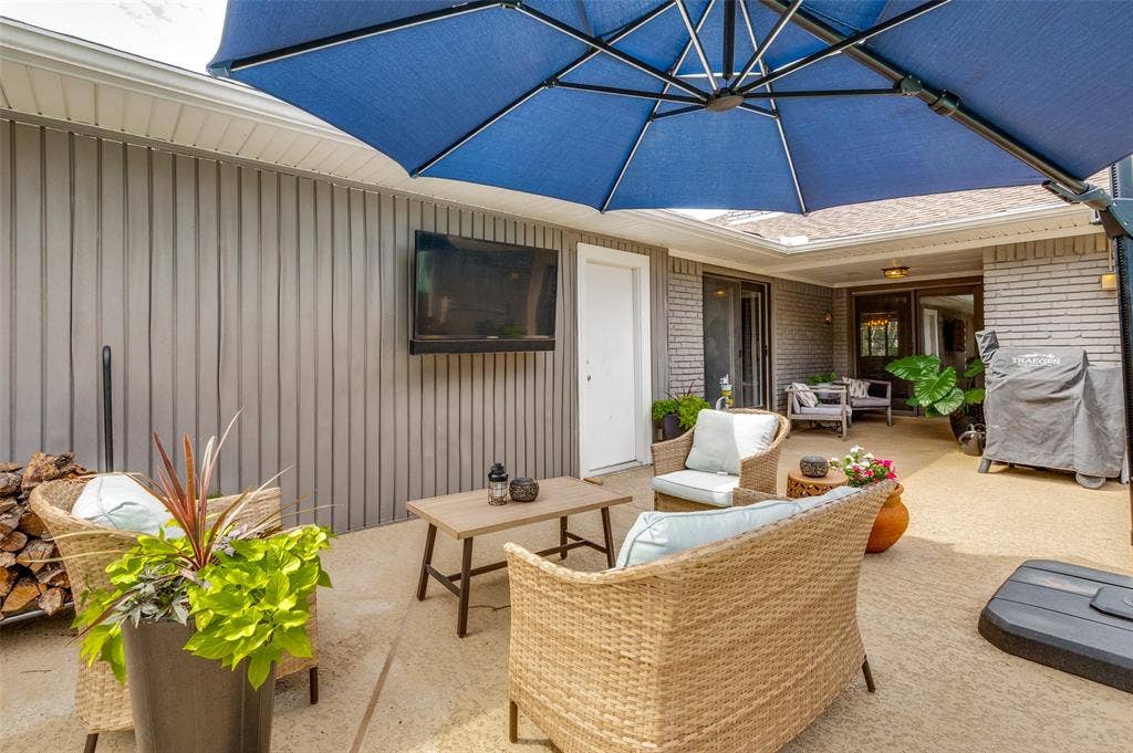 9421 Meadowknoll Drive, Dallas, TX 75243 Spacious outdoor patio area featuring a concrete surface, a built-in outdoor television, and a covered ceiling section