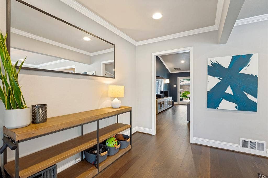9421 Meadowknoll Drive, Dallas, TX 75243 Hardwood flooring extends throughout this entryway featuring recessed lighting, crown molding, and an accent wall