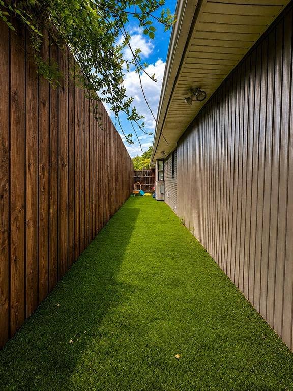 9421 Meadowknoll Drive, Dallas, TX 75243 Side yard featuring artificial turf and wood plank fencing