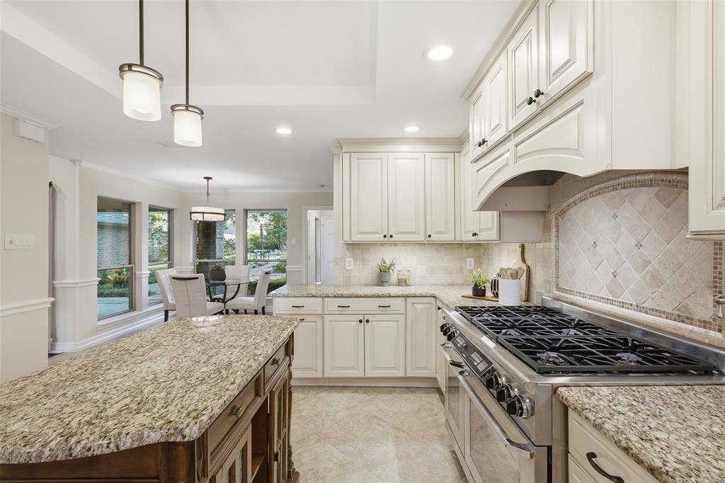 Arched range hood and mosaic-inlay backsplash add custom character to the heart of the home.