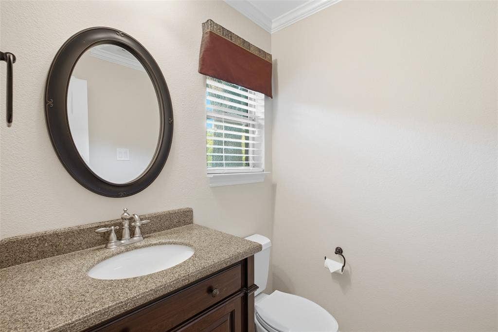 Convenient powder bath with granite vanity and oil-rubbed bronze accents for guests.